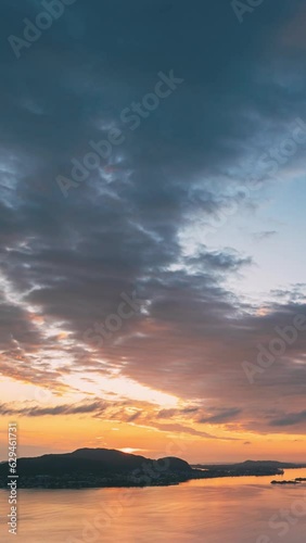 Alesund, Norway. Vertical Footage Video. Amazing Natural Bright Dramatic Sky In Warm Colours Above Alesund Valderoya And Islands In Sunset Time. Colorful Sky Background. Beauty In Norwegian Nature. photo