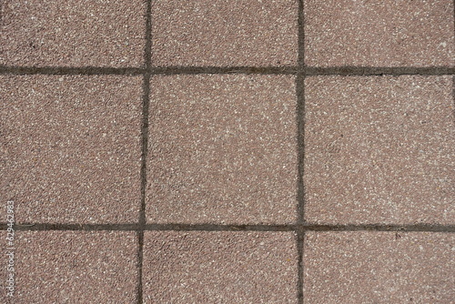 Texture of pavement made of pink tiles of resin bound gravel
