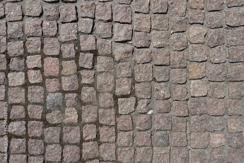 Rough surface of pavement made of rectangular pink granite stone setts photo