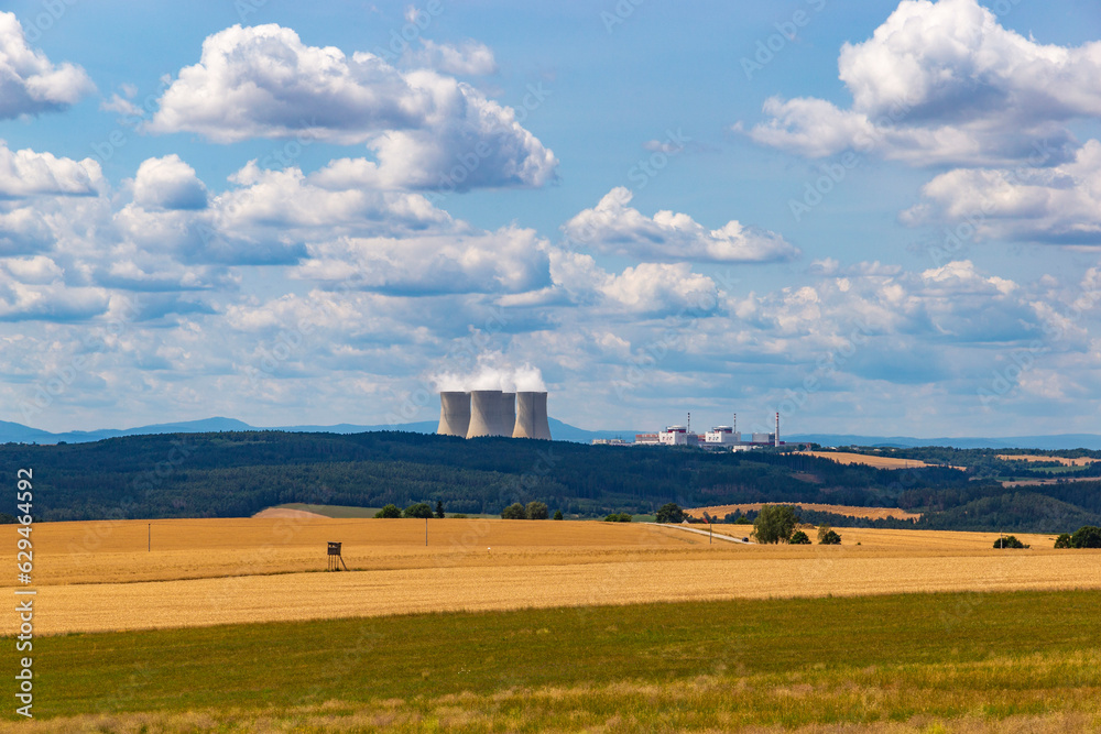 Summer fields and Temelin nuclear power plant on the horizon
