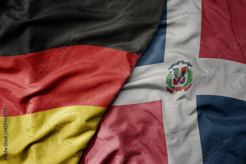 big waving realistic national colorful flag of germany and national flag of dominican republic .