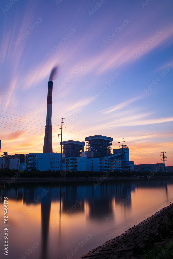 Obraz premium the riverside factory and the beautiful sunset glow