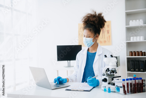 .Young scientists conducting research investigations in a medical laboratory  a researcher in the foreground is using a microscope in laboratory for medicine.