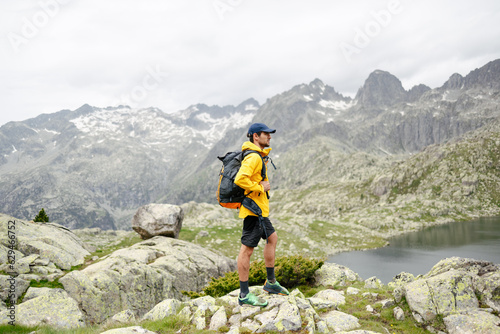 Young man standing on a rock with mountain background