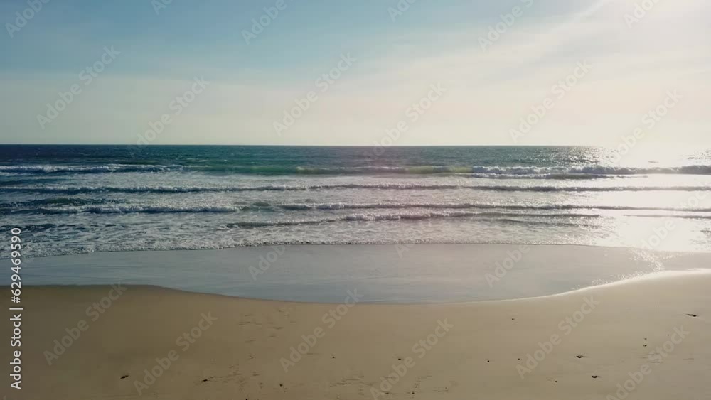 Aerial view of young happy couple sitting by the beach enjoying the sunset, vacation young concept. Drone view
