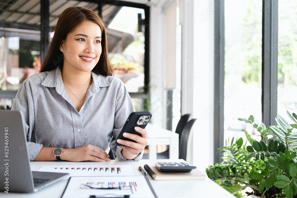 Thinking about how to take the business to technological heights. attractive cheerful young businesswoman working in her office. Thinking about how to take the business to technological heights. attractive cheerful young businesswoman working in her office.