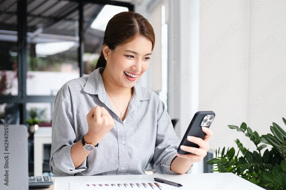 Happy Young Asian Business Woman Successful Excited Raised Hands Rejoicing With Smartphone. Happy Young Asian Business Woman Successful Excited Raised Hands Rejoicing With Smartphone.