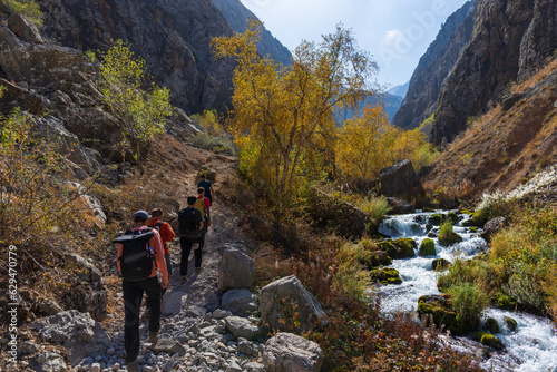 Beautiful autumn mountain landscape. Mountainous region of Uzbekistan. Tourist trail. Tourists are walking along the trail.