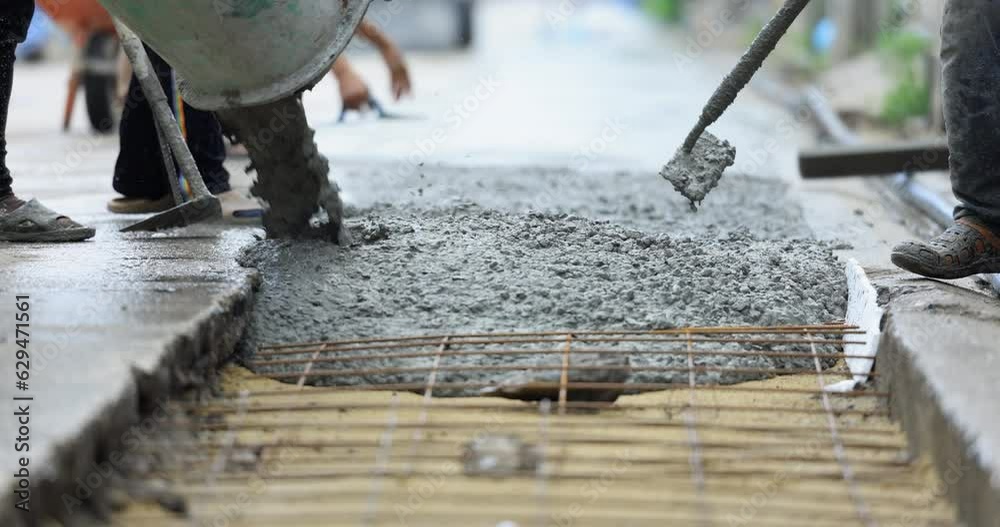 Mixer truck pouring cement concrete casting on reinforcing metal bars