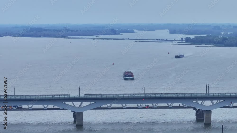 Train Crossing Moerdijk Bridges with Cargo Boats. Rotterdam The Netherlands filmed with a drone
