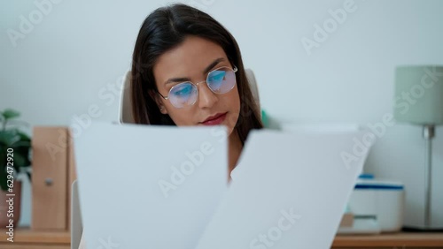 Video of elegant smart business woman working with computer while reading some notes in the office photo