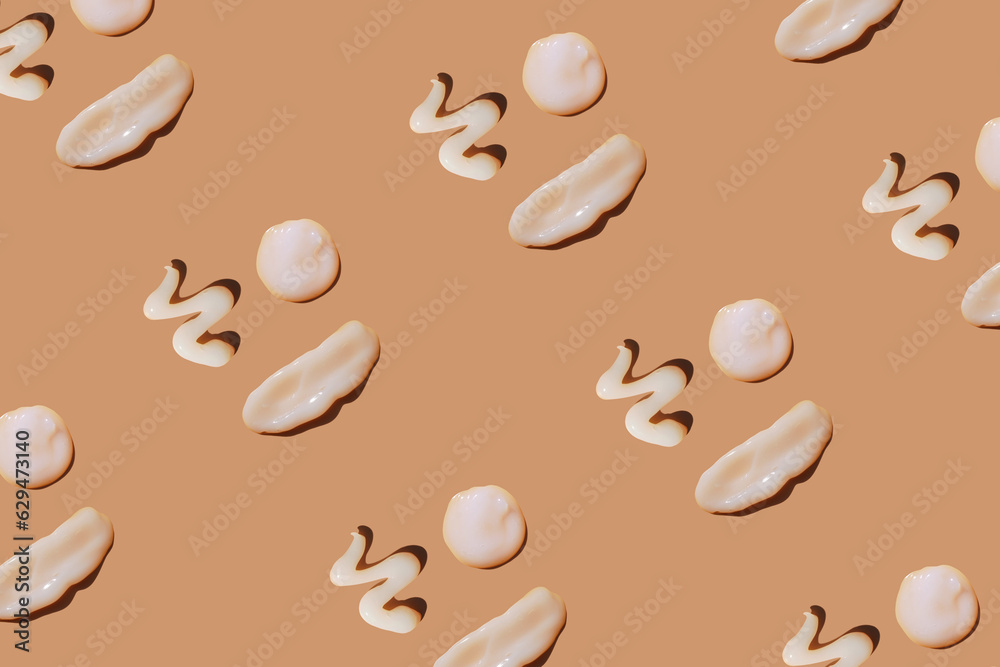 Obraz premium White сosmetic smears of creamy texture on a pastel background. Many happy face made of sunscreen. SPF sunblock cream. Pattern, natural skin care concept