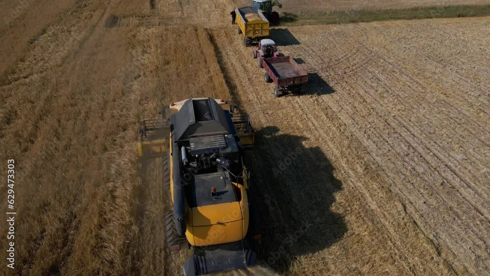 Harvesting machine working at agricultural field. Combine harvester collecting golden wheat field. Harvest reaping season Harvesting machine working at agricultural field. Combine harvester collecting golden wheat field. Harvest reaping season