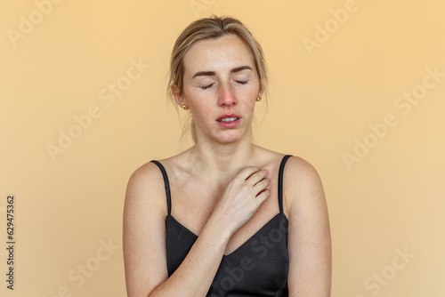 Young woman suffering from severe depression, anxiety, sadness, crying, standing over beige background. Unhappy girl feeling lonely and depressed, thinking about relationship or personal problems