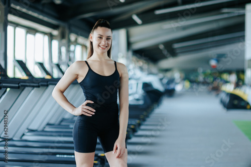 stunning gym portrait captures the beauty and athleticism of a young woman as she poses with poise and grace. Her contagious laughter and joyful demeanor radiate a sense of happiness