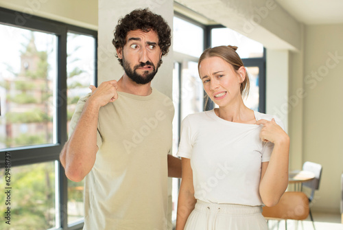 young adult couple feeling stressed, anxious, tired and frustrated, pulling shirt neck, looking frustrated with problem