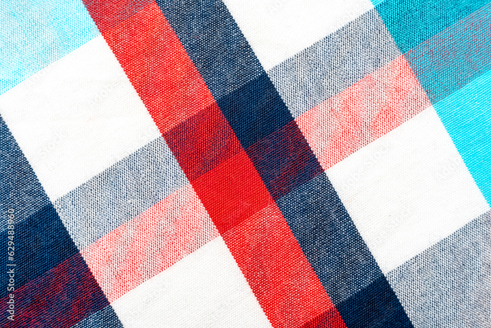 The texture of linen fabric in a large cell of red, blue and white. Scottish tailoring material. checkered fabric