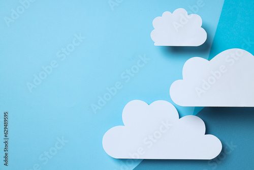 White, paper clouds on a blue background, place for text