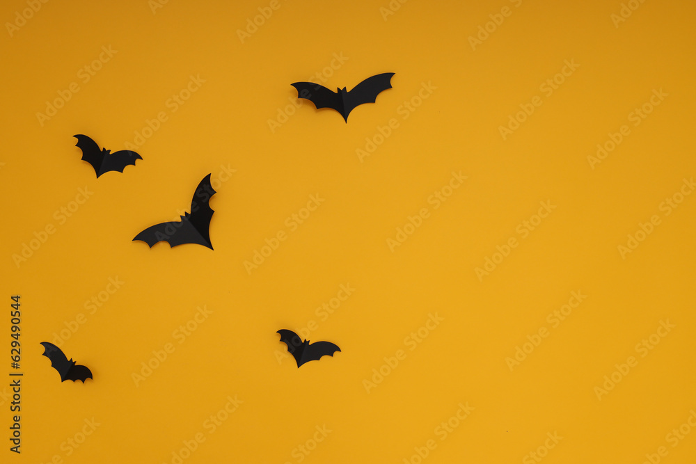 Fototapeta premium Yellow background with black bats, in Halloween style
