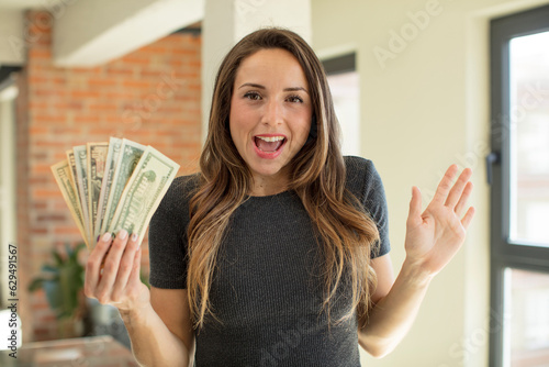 pretty woman feeling happy and astonished at something unbelievable. dollar banknotes concept