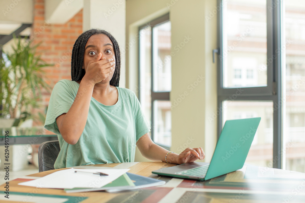 black afro woman covering mouth with a hand and shocked or surprised expression. studying concept black afro woman covering mouth with a hand and shocked or surprised expression. studying concept