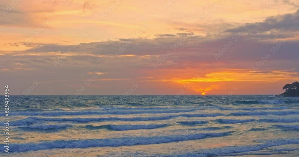 The sun is setting over the horizon and the waves of the sea are crashing towards the shore..Bright clouds as the sun sets over the horizon and waves of the sea come to shore.. The sun is setting over the horizon and the waves of the sea are crashing towards the shore..Bright clouds as the sun sets over the horizon and waves of the sea come to shore..