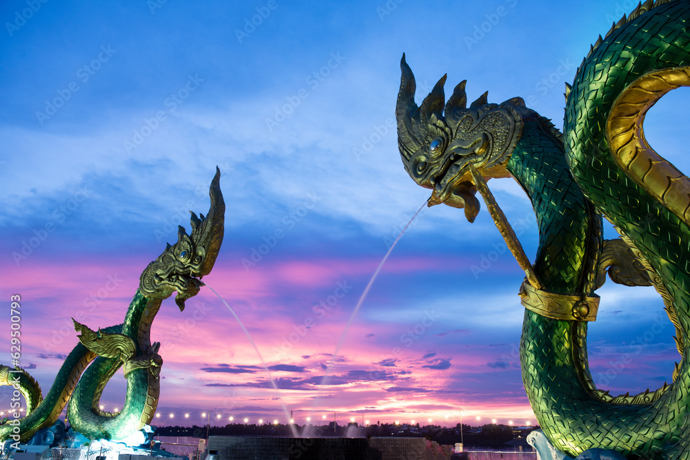 Big green naga statue in riverside on mekong river is landmark in nongkhai city Thailand with twilight background. - obrazy, fototapety, plakaty 
