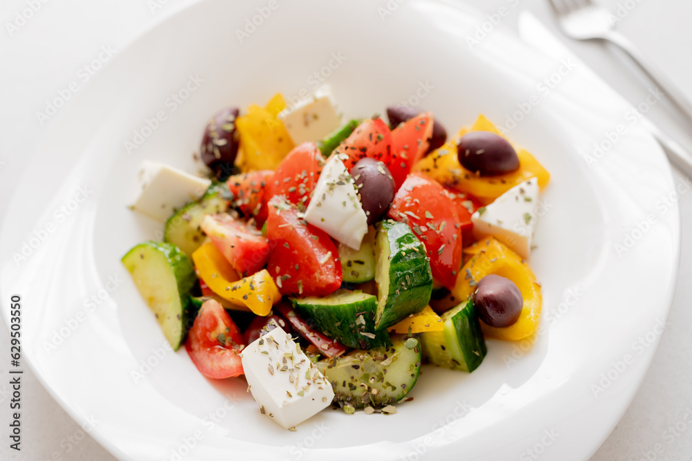 Greek salad with cucumber, tomato, sweet pepper, feta cheese, olives filled with oil. Healthy food. Close up
