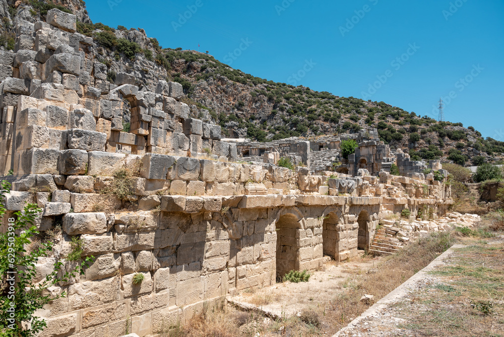 The ruins of the amphitheater and ancient rock tombs in the ancient city of Myra in Demre, Turkey