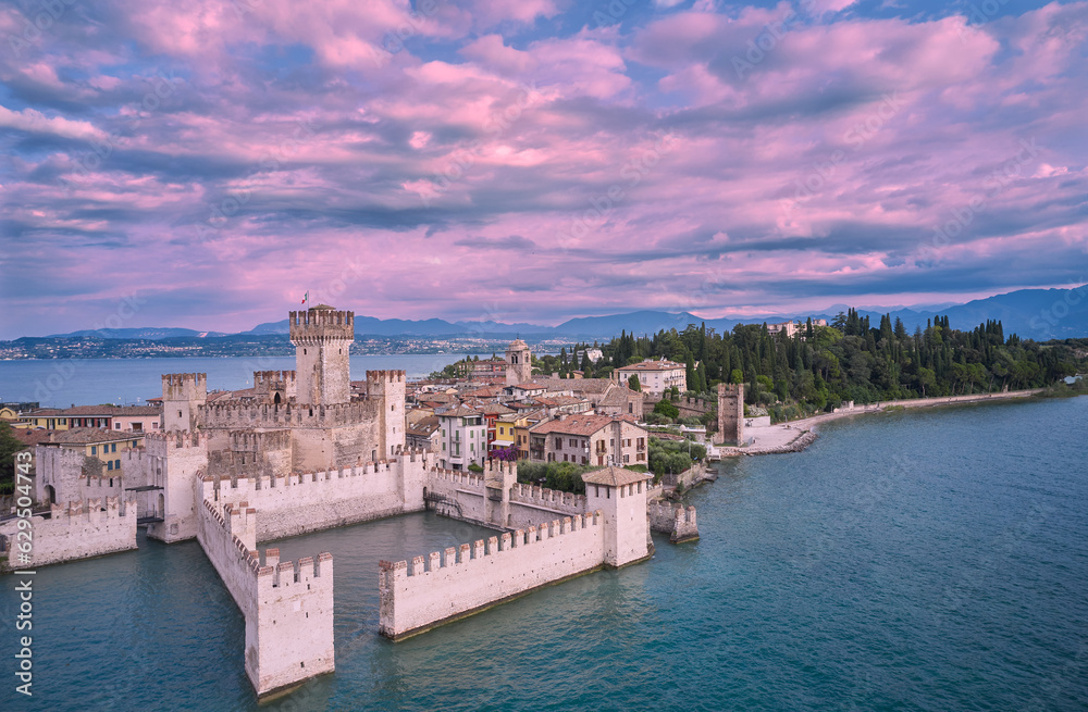 Morning view of Scaliger Castle Sirmione. Scaliger Castle Sirmione on Lake Garda in Italy. Pink clouds over Scaliger Castle.