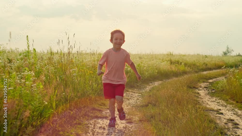 Slow motion lifestyle video of a boy running across a field in the sun. The concept of the freedom of children's dreams of relaxation and sports. High quality 4k footage Slow motion lifestyle video of a boy running across a field in the sun. The concept of the freedom of children's dreams of relaxation and sports. High quality 4k footage