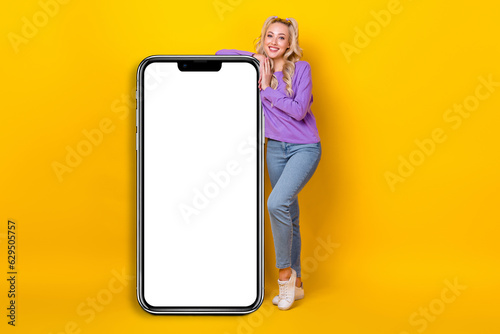 Full length photo of shiny sweet woman wear violet shirt holding modern gadget emtpy space isolated yellow color background