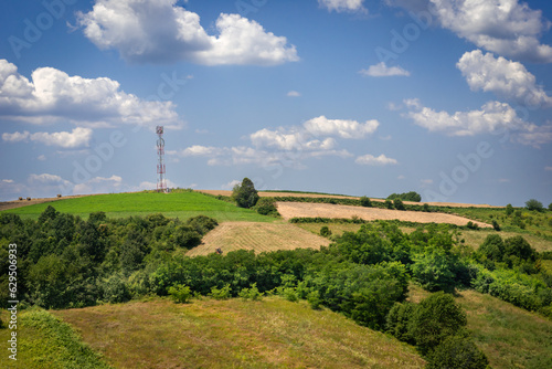 Idyllic landscape with antenna in background with blue sky and clouds, Serbia