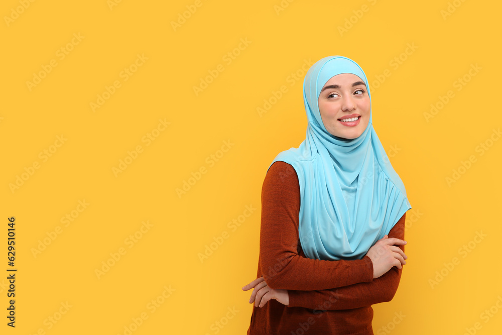 Portrait of Muslim woman in hijab on orange background, space for text Portrait of Muslim woman in hijab on orange background, space for text