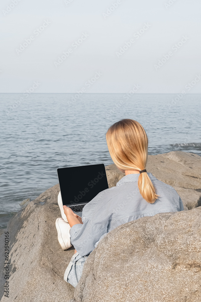 Remote work.Girl freelancer works remotely on the sea shore.workation, remote work,WFVH,Van Life vibes work from vacation home,work travel,remotely work.Travelling.Work from vacation remotely