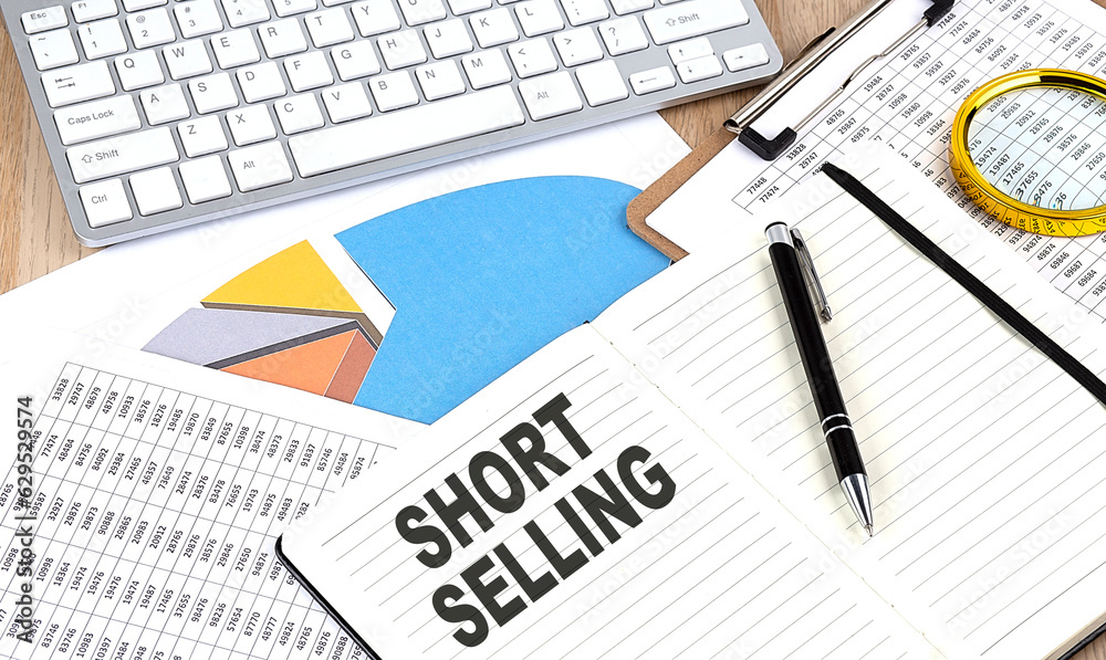 SHORT SELLING text on notebook with chart and keyboard SHORT SELLING text on notebook with chart and keyboard