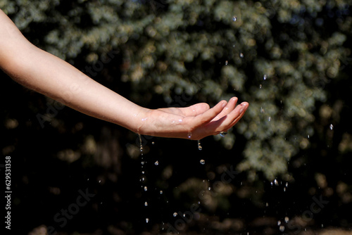 Water falling on a hand of a Caucasian child
