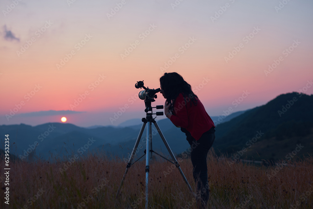 Female astronomer looking at the sun with a telescope.