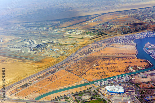 Airplane view of Abu Dhabi International Airport, streets, roads and residential buildings of the city