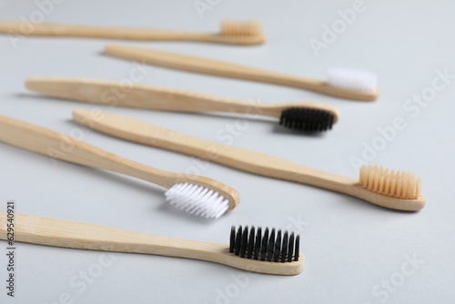 Many different bamboo toothbrushes on white background