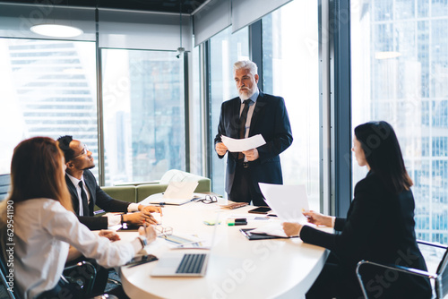 Group of diverse colleagues understanding project details in office