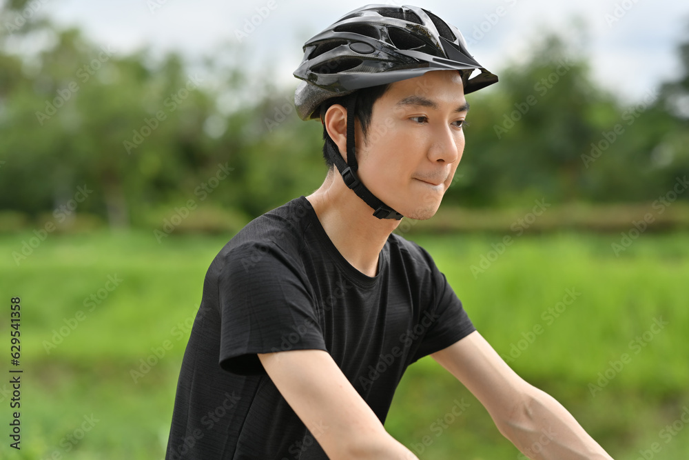 Image of sporty man riding a bicycle on country road. Travel, sport and active lifestyle concept Image of sporty man riding a bicycle on country road. Travel, sport and active lifestyle concept
