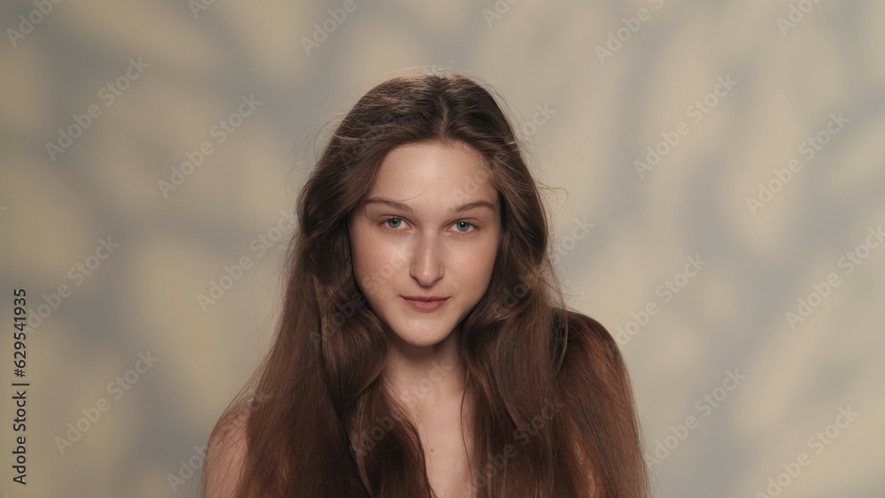 Beautiful young model with fresh skin and long shiny hair looking at the camera Beautiful young model with fresh skin and long shiny hair looking at the camera