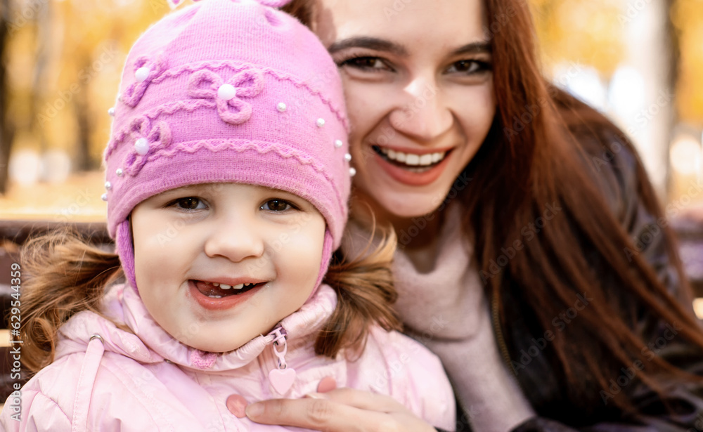 Obraz premium Happy family mom and little girl playing outdoors in autumn park. Little girl and her mother in the autumn park. soft focus