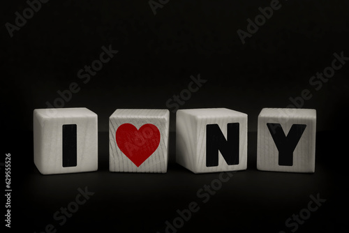 Message I LOVE NEW YORK written with wooden blocks on dark background. Studio shot of a textual message taken using wooden cubes aligned on a low-key set.
