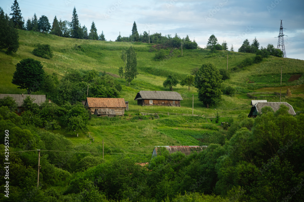 Wooden traditional houses against the backdrop of a mountain landscape, Ukrainian Carpathians.