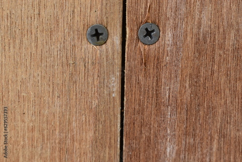Photo of two screws in a wooden wall