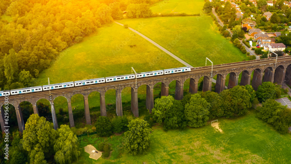 UK Commuter Train Travelling Across a Viaduct at Sunset.