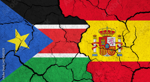 Flags of South Sudan and Spain on cracked surface - politics, relationship concept