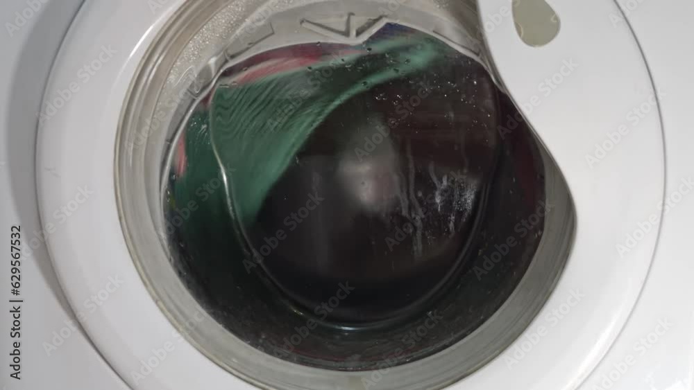 a washing machine with a red and black object inside the front door and a red and black object in front of the facade, motion blur,